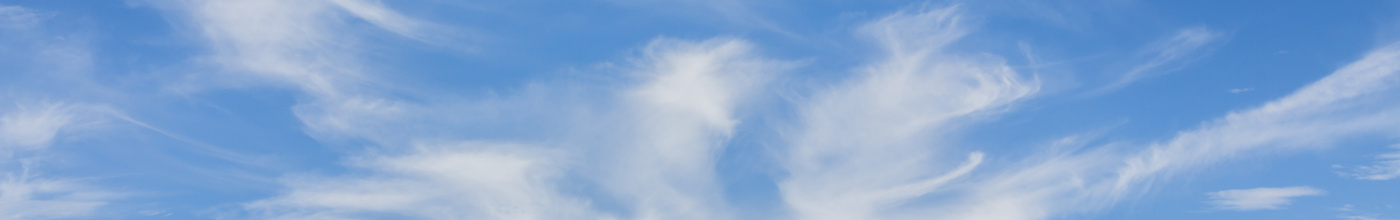 A landscape image of a blue sky with wispy clouds